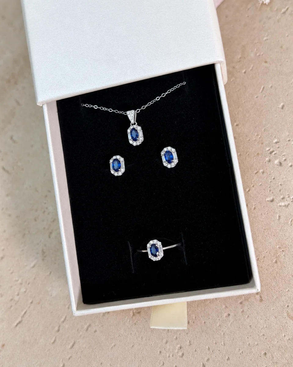 Set Zafiro: collar, pendientes y anillo con zafiro natural en su caja, vista cenital – Maison Akari